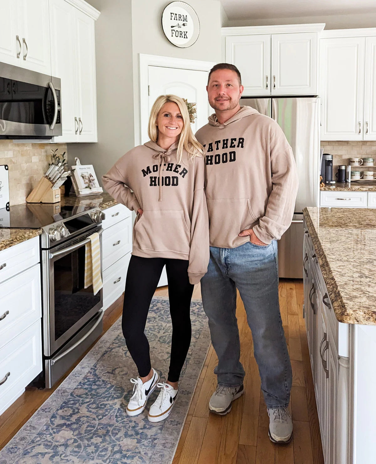 A mom and dad wearing Mother and Fatherhood Hoodies
